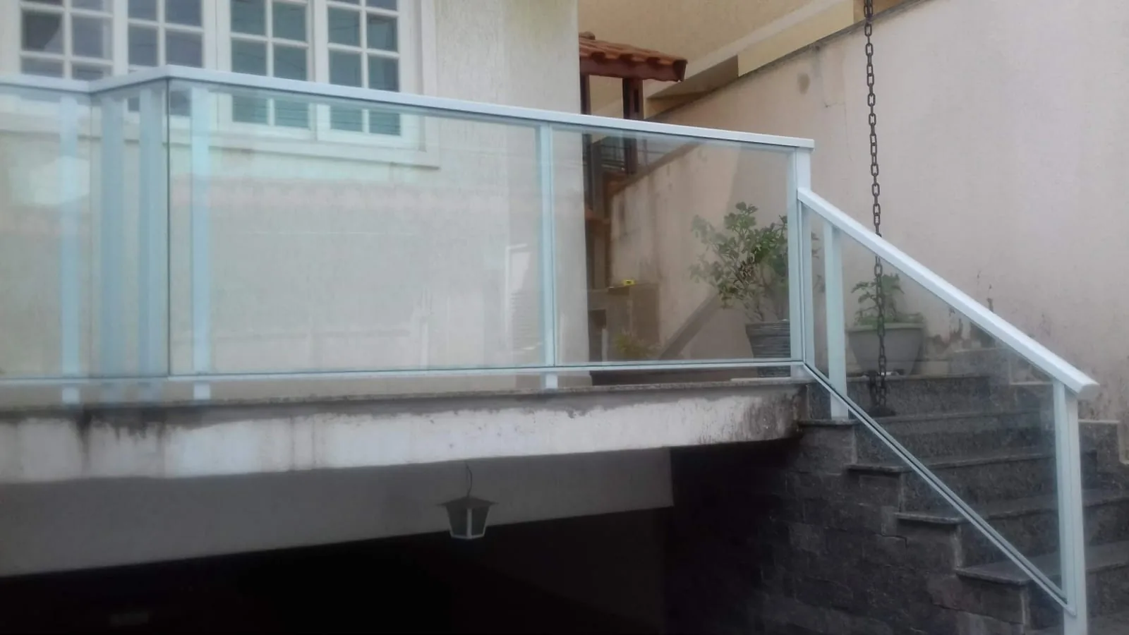 Guarda-corpo de vidro com corrimão em varanda