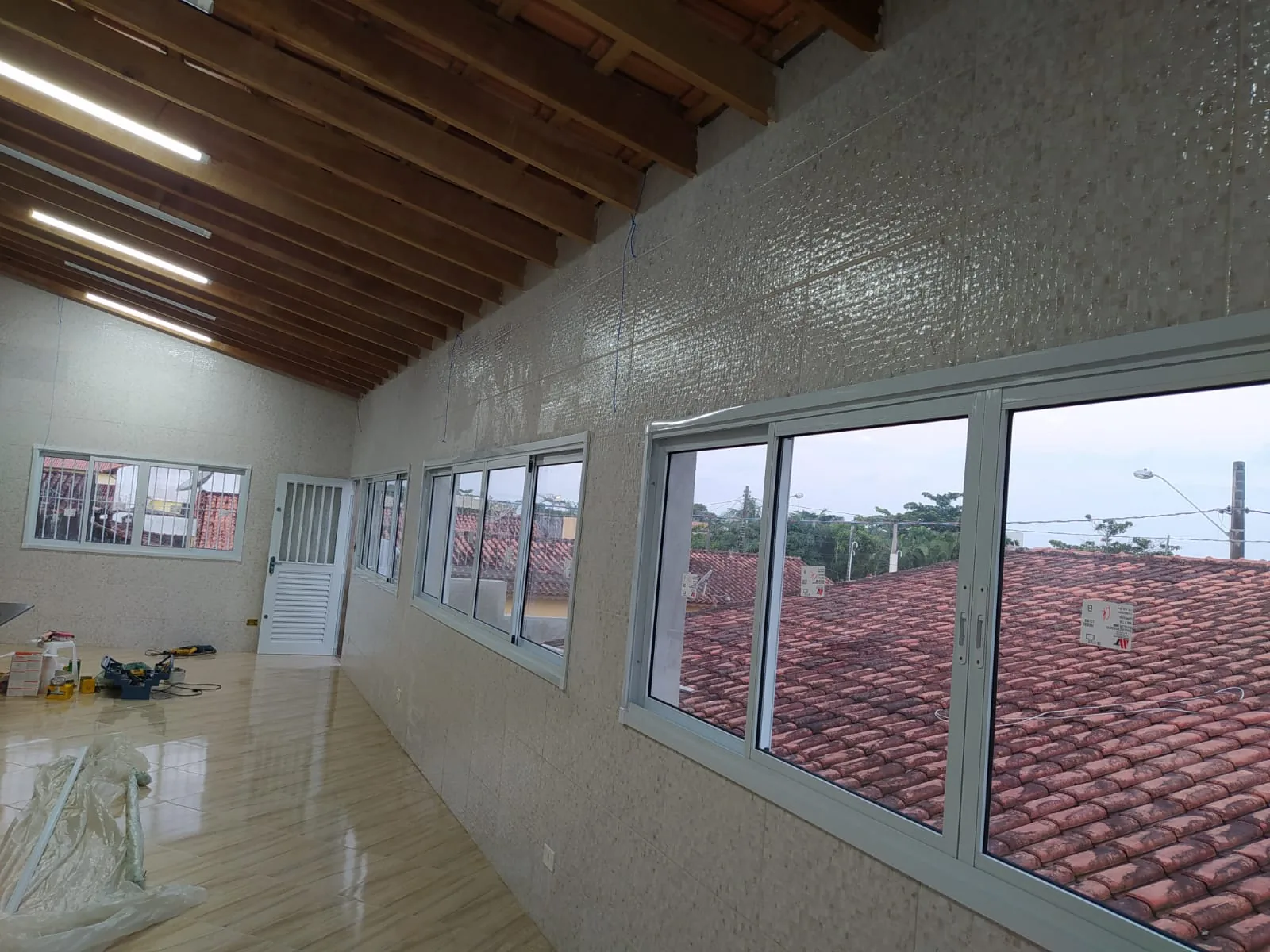 Fita de janelas de alumínio em ambiente com telhado de madeira aparente