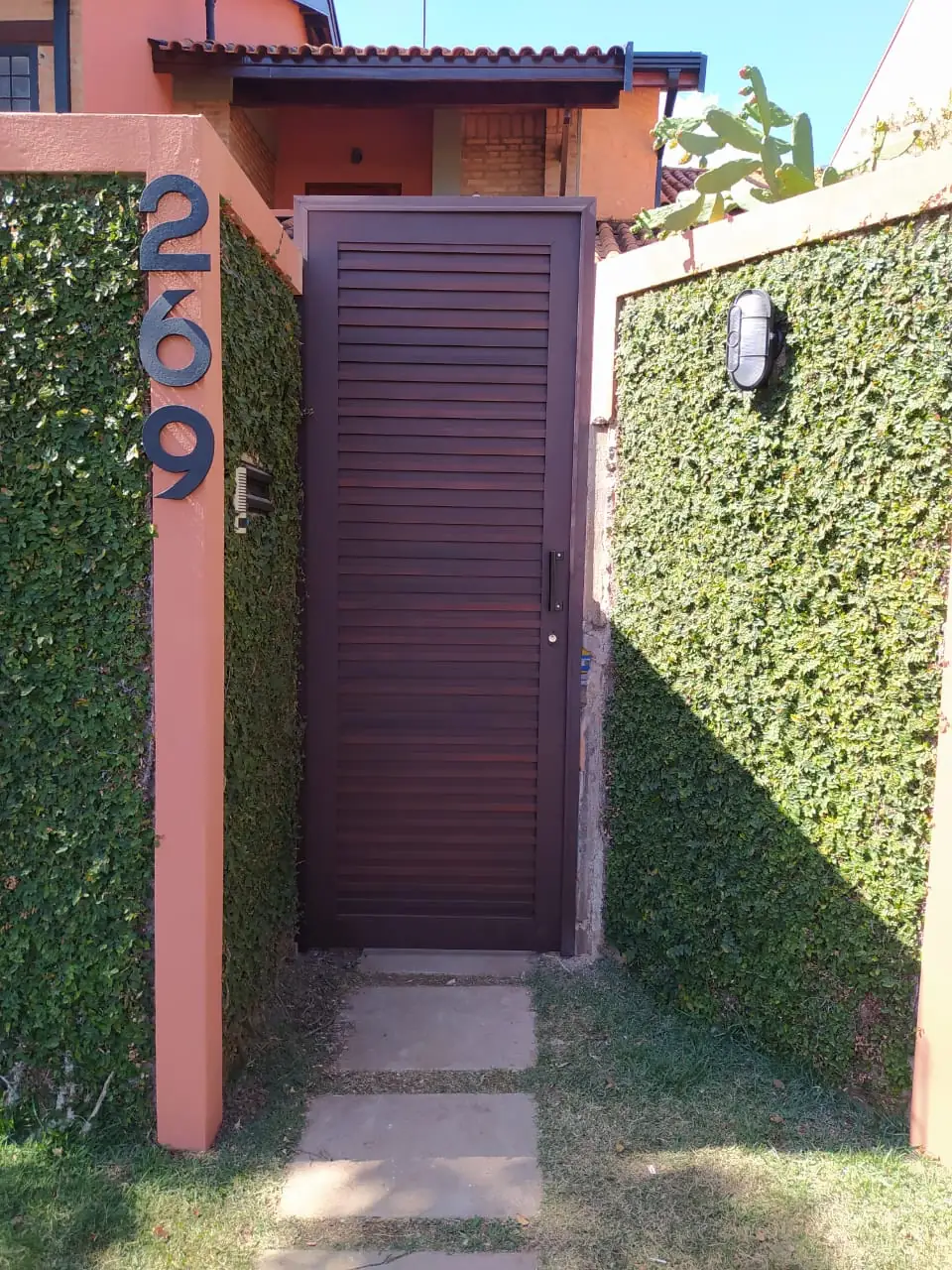 Porta social de alumínio amadeirado com acabamento de madeira